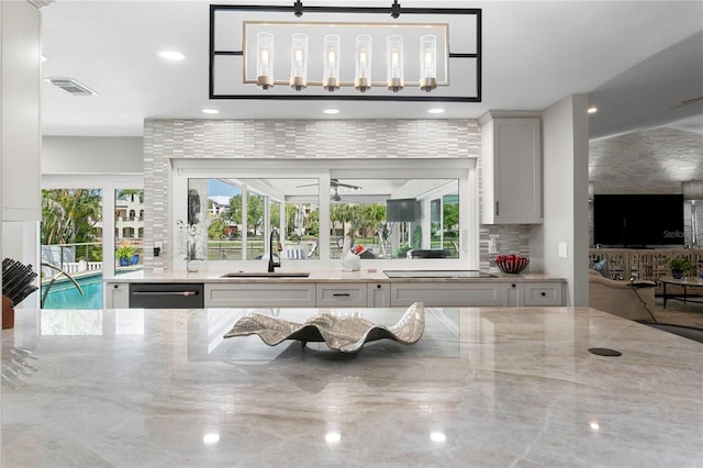 2817 Seabreeze Dr S, Gulfport, FL 33707 - kitchen featuring a sink, light stone counters, backsplash, dishwashing machine, and recessed lighting