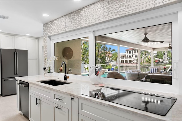 2817 Seabreeze Dr S, Gulfport, FL 33707 - kitchen featuring high quality fridge, a sink, black electric cooktop, stainless steel dishwasher, and white cabinetry