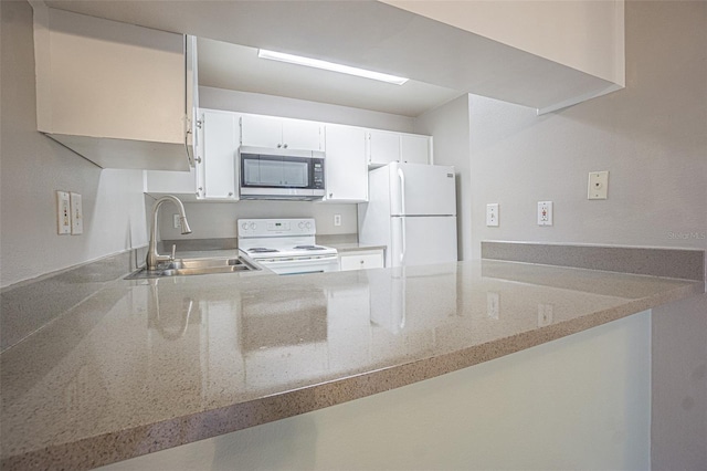 3002 W Cleveland St Unit C3, Tampa, FL 33609 - kitchen with white appliances, a sink, a peninsula, and light stone countertops