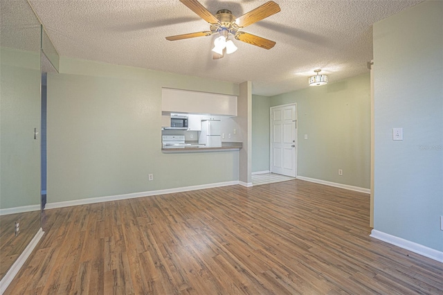 3002 W Cleveland St Unit C3, Tampa, FL 33609 - unfurnished living room featuring wood finished floors, a ceiling fan, a textured ceiling, and baseboards