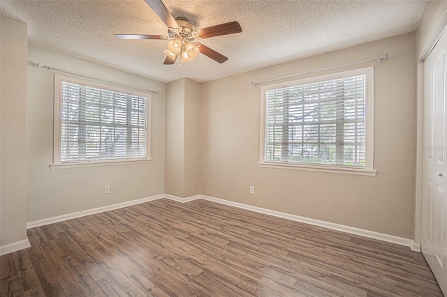 3002 W Cleveland St Unit C3, Tampa, FL 33609 - empty room with healthy amount of natural light, wood finished floors, a textured ceiling, a ceiling fan, and baseboards
