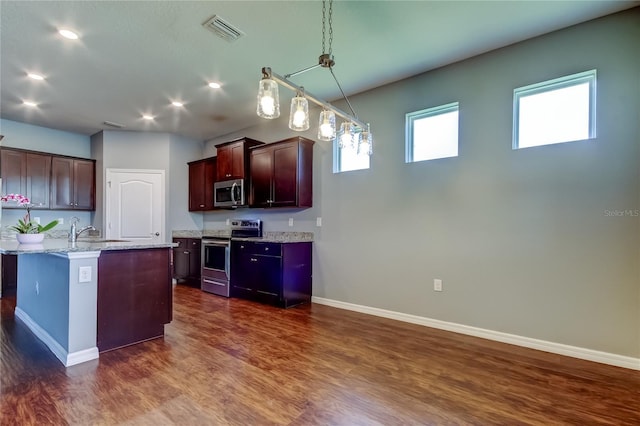 kitchen with appliances with stainless steel finishes, a sink, dark wood-style flooring, baseboards, and recessed lighting