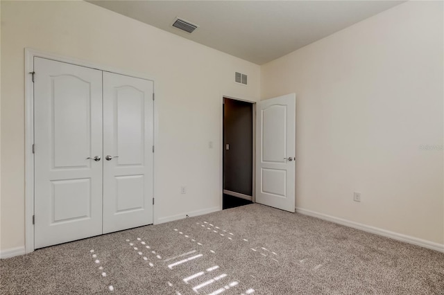 unfurnished bedroom with carpet flooring, baseboards, and a closet