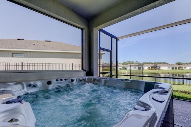 exterior space featuring fence, a water view, and a hot tub