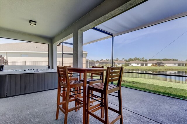 sunroom featuring a residential view, a water view, and plenty of natural light
