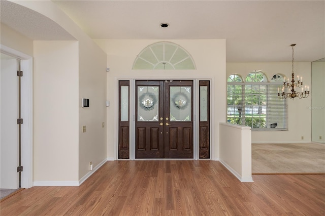 627 Belted Kingfisher Dr N, Palm Harbor, FL 34683 - foyer with light wood finished floors, baseboards, and a chandelier