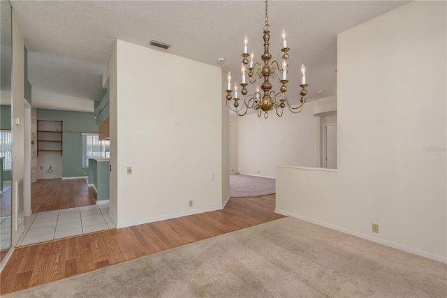 627 Belted Kingfisher Dr N, Palm Harbor, FL 34683 - spare room with carpet floors, a chandelier, wood finished floors, and baseboards
