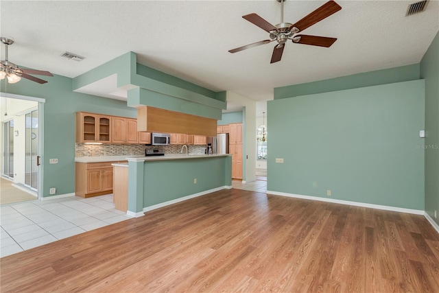 627 Belted Kingfisher Dr N, Palm Harbor, FL 34683 - kitchen with ceiling fan, appliances with stainless steel finishes, light wood finished floors, light countertops, and open floor plan