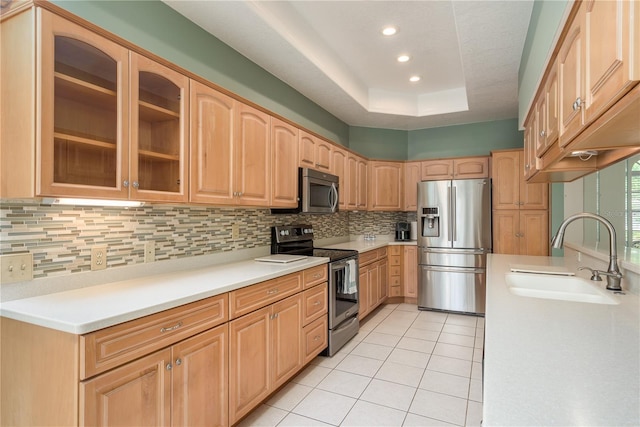 627 Belted Kingfisher Dr N, Palm Harbor, FL 34683 - kitchen featuring appliances with stainless steel finishes, a sink, decorative backsplash, light brown cabinetry, and glass insert cabinets