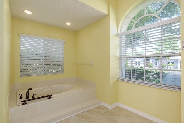 627 Belted Kingfisher Dr N, Palm Harbor, FL 34683 - bathroom with a garden tub, a textured ceiling, tile patterned flooring, baseboards, and recessed lighting