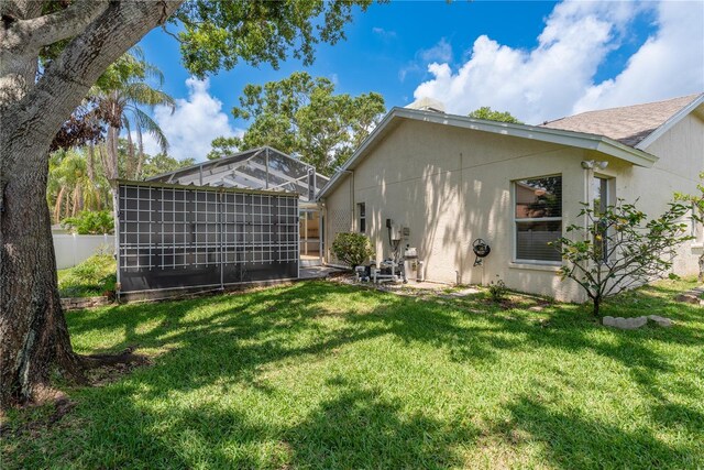 627 Belted Kingfisher Dr N, Palm Harbor, FL 34683 - back of house featuring stucco siding and a lanai