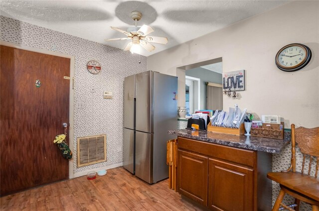 28 N Edinburgh Dr, Inverness, FL 34450 - kitchen featuring freestanding refrigerator, light wood-style flooring, a ceiling fan, brown cabinetry, and dark stone countertops