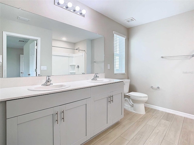 34056 Scarlet Sage Ct, Wesley Chapel, FL 33545 - full bathroom featuring toilet, wood finished floors, a shower, double vanity, and baseboards