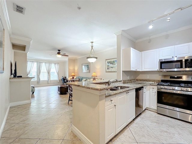 2724 Via Murano Unit 615, Clearwater, FL 33764 - kitchen with appliances with stainless steel finishes, a sink, light tile patterned floors, open floor plan, and crown molding