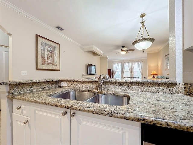 2724 Via Murano Unit 615, Clearwater, FL 33764 - kitchen with a sink, crown molding, ceiling fan, light stone counters, and white cabinets