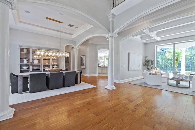 4512 Cheval Blvd, Lutz, FL 33558 - unfurnished living room with hardwood / wood-style floors, ornate columns, arched walkways, coffered ceiling, and a high ceiling