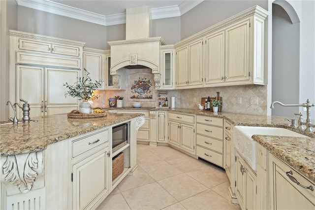 4512 Cheval Blvd, Lutz, FL 33558 - kitchen featuring cream cabinets, light stone countertops, a sink, decorative backsplash, and crown molding