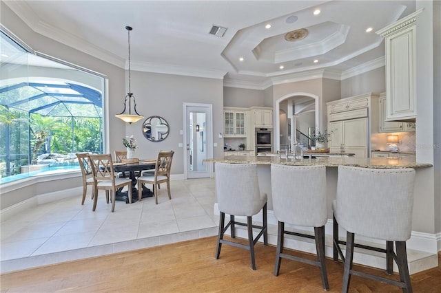4512 Cheval Blvd, Lutz, FL 33558 - kitchen with a raised ceiling, light stone countertops, recessed lighting, a peninsula, and ornamental molding