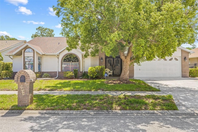 5434 Wellfield Rd, New Port Richey, FL 34655 - view of front of home with concrete driveway, an attached garage, stucco siding, and brick siding