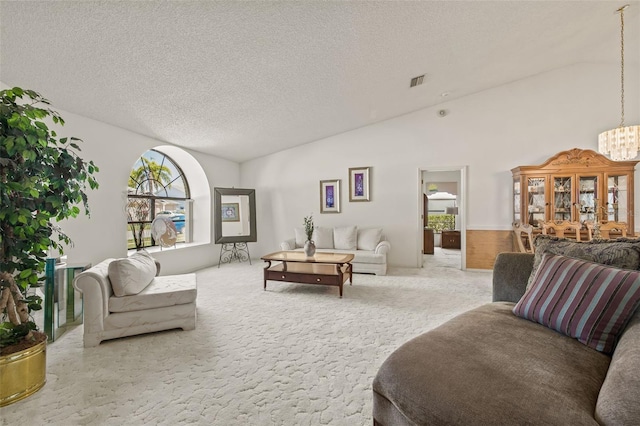 5434 Wellfield Rd, New Port Richey, FL 34655 - carpeted living room featuring vaulted ceiling, a chandelier, and a textured ceiling