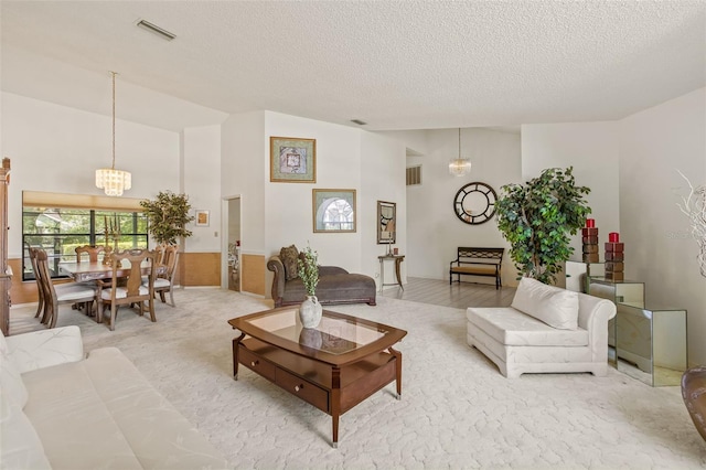 5434 Wellfield Rd, New Port Richey, FL 34655 - living area with a chandelier, a textured ceiling, lofted ceiling, and carpet flooring