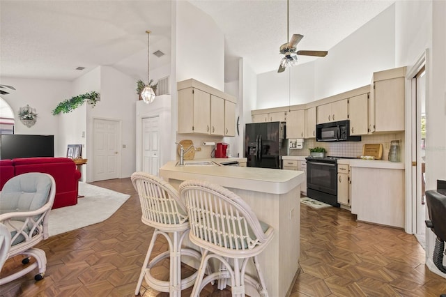 5434 Wellfield Rd, New Port Richey, FL 34655 - kitchen featuring black appliances, cream cabinets, a sink, light countertops, and ceiling fan