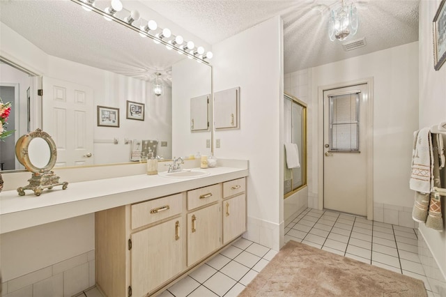 5434 Wellfield Rd, New Port Richey, FL 34655 - full bathroom with bath / shower combo with glass door, tile patterned floors, vanity, and a textured ceiling