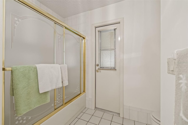 5434 Wellfield Rd, New Port Richey, FL 34655 - full bath with tile patterned flooring, enclosed tub / shower combo, toilet, and a textured ceiling