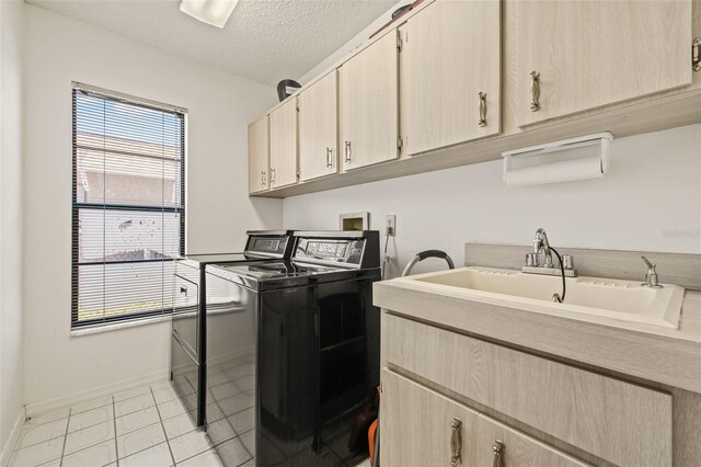 5434 Wellfield Rd, New Port Richey, FL 34655 - laundry room with independent washer and dryer, cabinet space, baseboards, light tile patterned floors, and a textured ceiling