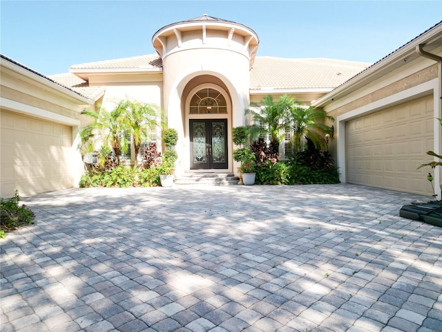 15101 Kestrelglen Way, Lithia, FL 33547 - view of exterior entry with french doors, decorative driveway, a tile roof, and a garage