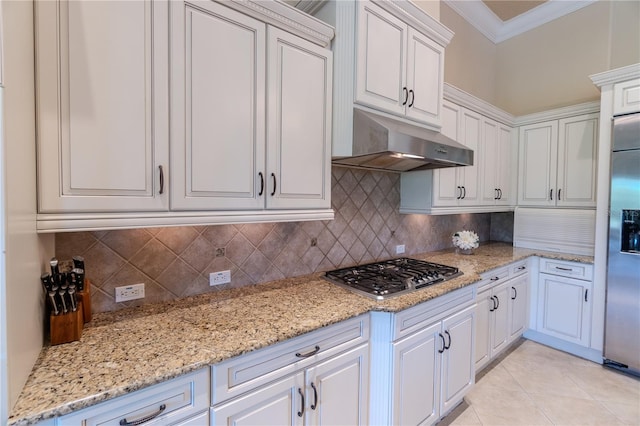15101 Kestrelglen Way, Lithia, FL 33547 - kitchen with appliances with stainless steel finishes, under cabinet range hood, crown molding, white cabinetry, and decorative backsplash