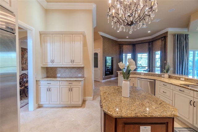15101 Kestrelglen Way, Lithia, FL 33547 - kitchen with appliances with stainless steel finishes, ornamental molding, tasteful backsplash, a chandelier, and light stone countertops