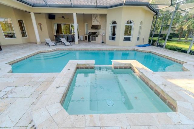 15101 Kestrelglen Way, Lithia, FL 33547 - view of pool featuring an outdoor kitchen, a patio, a pool with connected hot tub, a ceiling fan, and a lanai