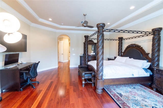 15101 Kestrelglen Way, Lithia, FL 33547 - bedroom featuring crown molding, wood finished floors, arched walkways, baseboards, and a tray ceiling