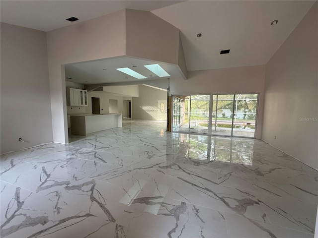 14273 Nugent Cir, Spring Hill, FL 34609 - spare room featuring a skylight, light marble finish flooring, and a towering ceiling
