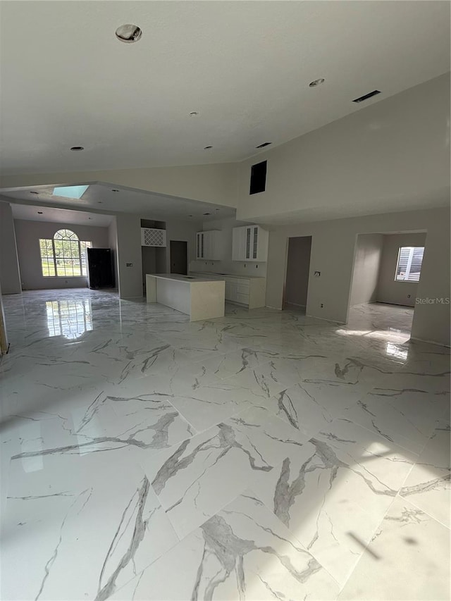 14273 Nugent Cir, Spring Hill, FL 34609 - unfurnished room featuring high vaulted ceiling, healthy amount of natural light, and light marble finish flooring