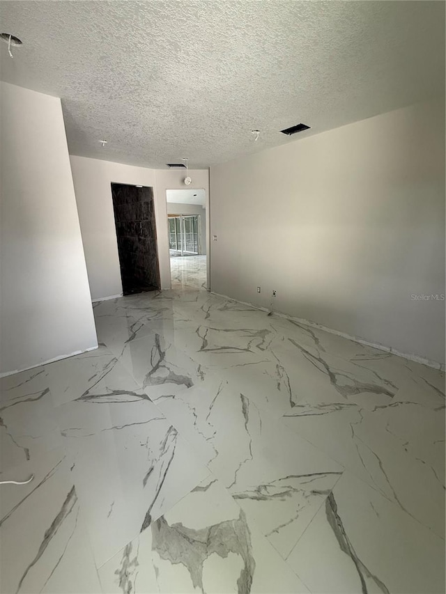 14273 Nugent Cir, Spring Hill, FL 34609 - empty room featuring a textured ceiling and marble finish floors