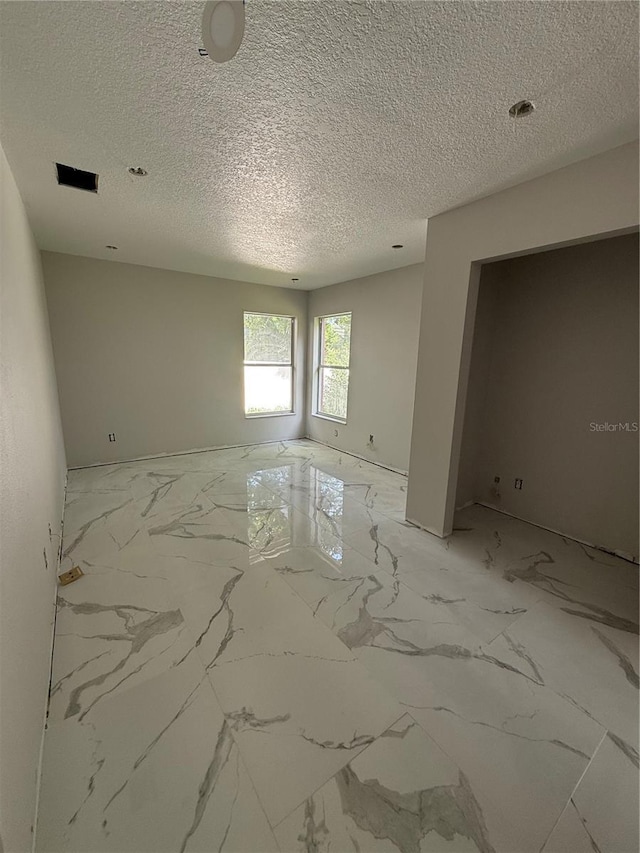 14273 Nugent Cir, Spring Hill, FL 34609 - spare room with light marble finish floors and a textured ceiling