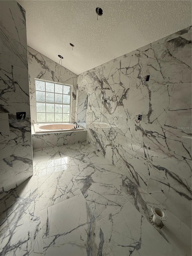 14273 Nugent Cir, Spring Hill, FL 34609 - full bath with a textured ceiling, a tub with marble appearance, stone wall, marble tiled floors, and a marble finish shower