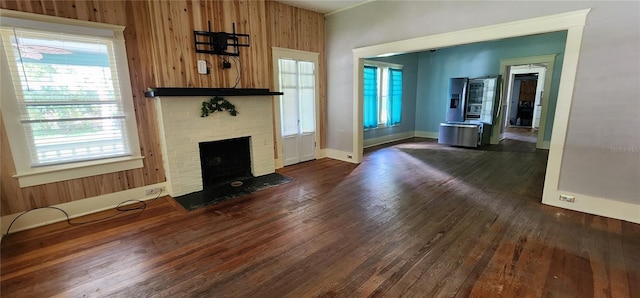 138 S Hernando Ave, Arcadia, FL 34266 - unfurnished living room featuring dark wood-type flooring, plenty of natural light, and wooden walls