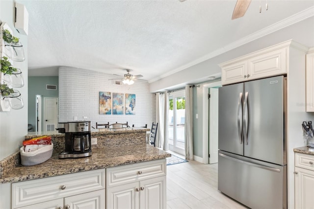 1818 Indian Rocks Rd S, Largo, FL 33774 - kitchen featuring freestanding refrigerator, ceiling fan, a textured ceiling, stone counters, and ornamental molding