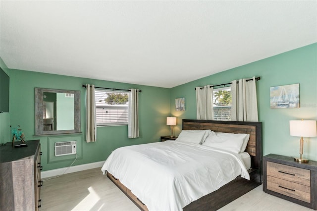 1818 Indian Rocks Rd S, Largo, FL 33774 - bedroom with multiple windows, a wall mounted air conditioner, light wood finished floors, and baseboards