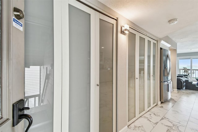 corridor featuring light marble finish floors