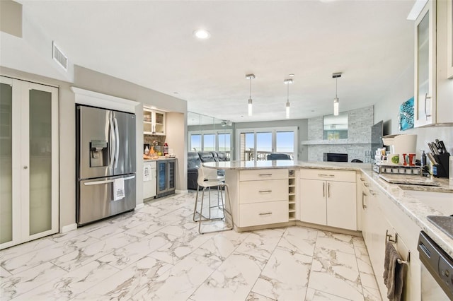 kitchen featuring stainless steel appliances, a peninsula, wine cooler, decorative backsplash, and decorative light fixtures