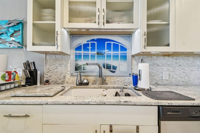 kitchen with dishwasher, a sink, tasteful backsplash, and white cabinetry