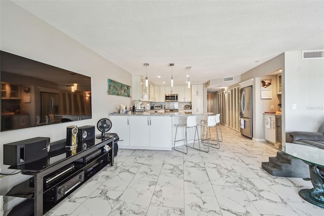 living area with light marble finish floors and a textured ceiling