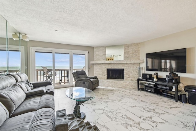 living room featuring marble look tile flooring, a textured ceiling, and a fireplace