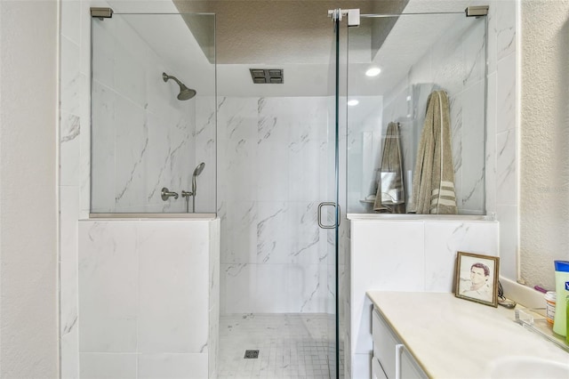 full bath with a marble finish shower and vanity
