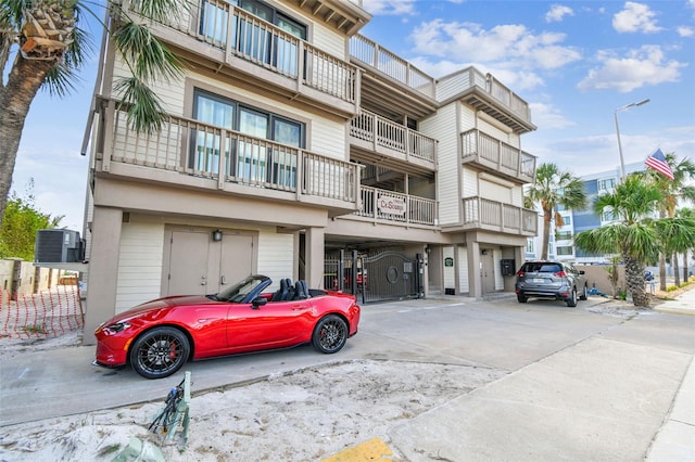 view of property with concrete driveway and central AC