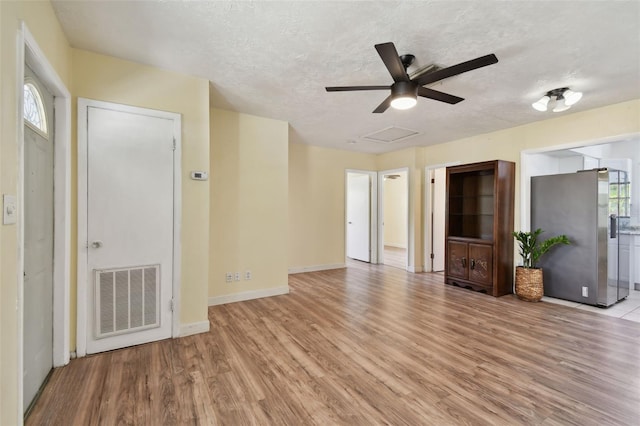 1810 77th Ave N, Saint Petersburg, FL 33702 - unfurnished living room featuring light wood-style floors, ceiling fan, a textured ceiling, and baseboards